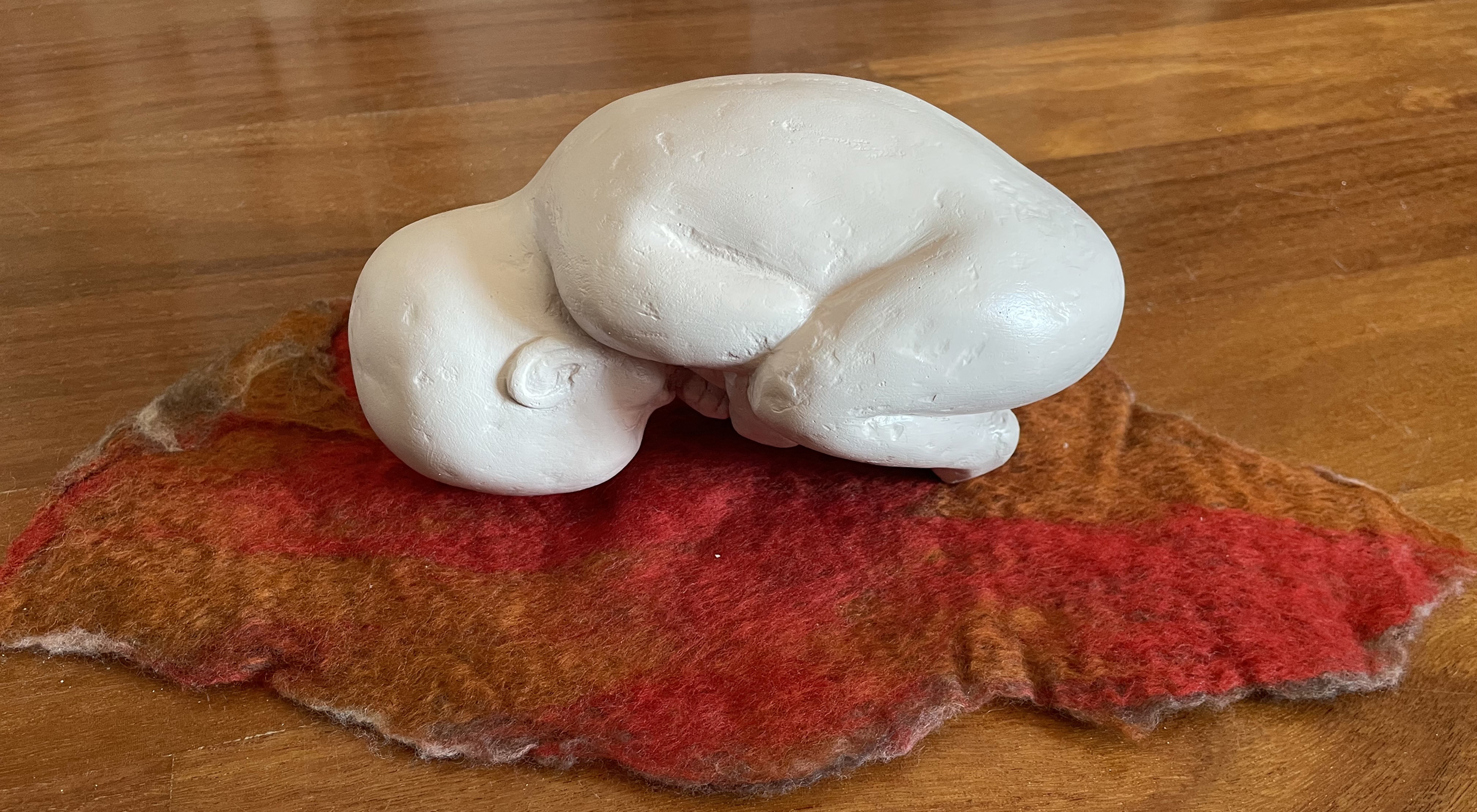 Bebé escultura de bebé en posición fetal